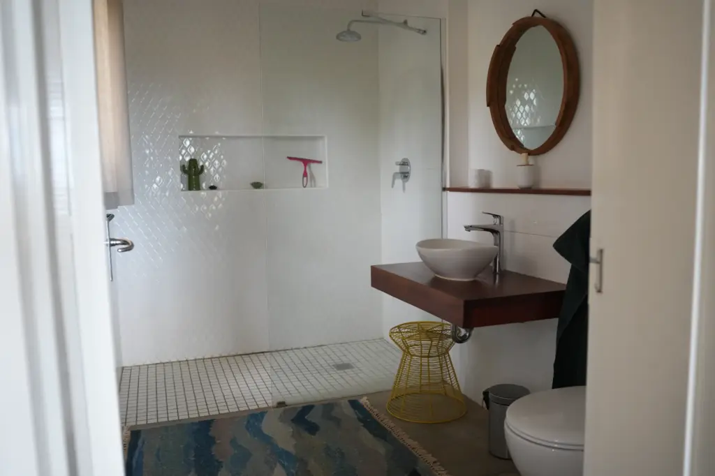 Modernes Badezimmer mit Dusche, Waschtisch und Holzdetails auf namibischer Jagdfarm