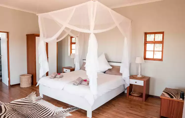 Double bed with mosquito net at Haris hunting lodge